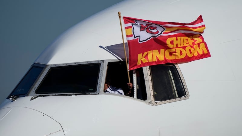 A Kansas City Chiefs flag flies from the team plane as they arrive ahead of Super Bowl 57,...