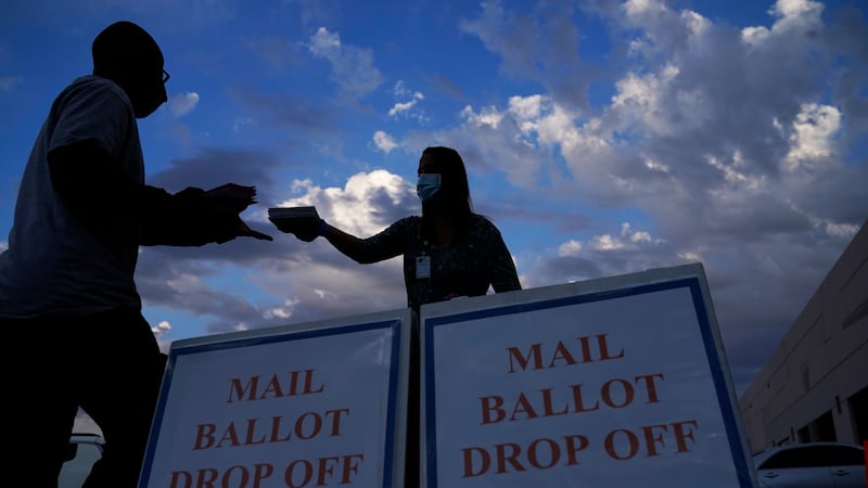 A county worker collects a mail-in ballots in a drive-thru mail-in ballot drop off area at the...