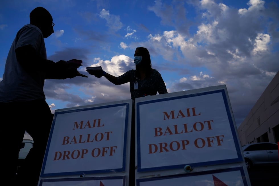 A county worker collects a mail-in ballots in a drive-thru mail-in ballot drop off area at the...