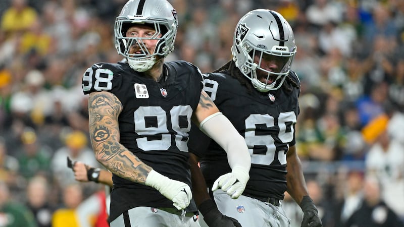 Las Vegas Raiders' Maxx Crosby and Adam Butler celebrate a stop for a loss during the first...