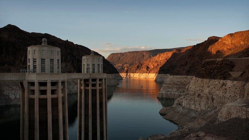 FILE - A bathtub ring of light minerals shows the high water line of Lake Mead near water...