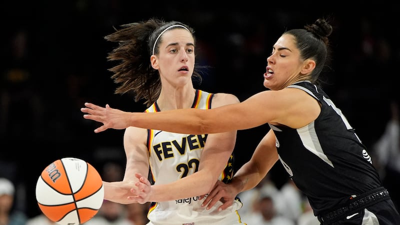 Indiana Fever guard Caitlin Clark (22) passes around Las Vegas Aces guard Kelsey Plum during...