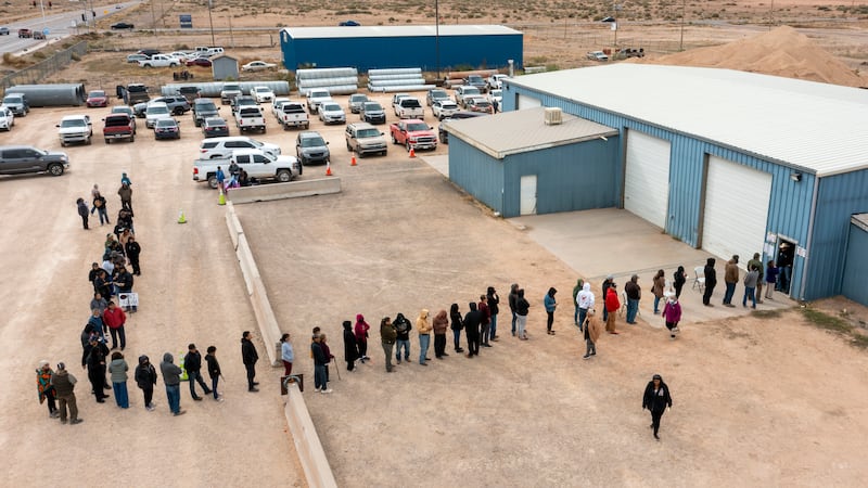 Voters wait in line to cast their ballots outside a polling station on the Navajo Nation in...