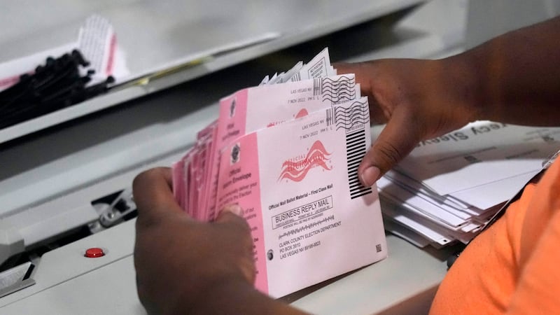 FILE - An election worker prepares mail-in ballots at the Clark County Election Department on...