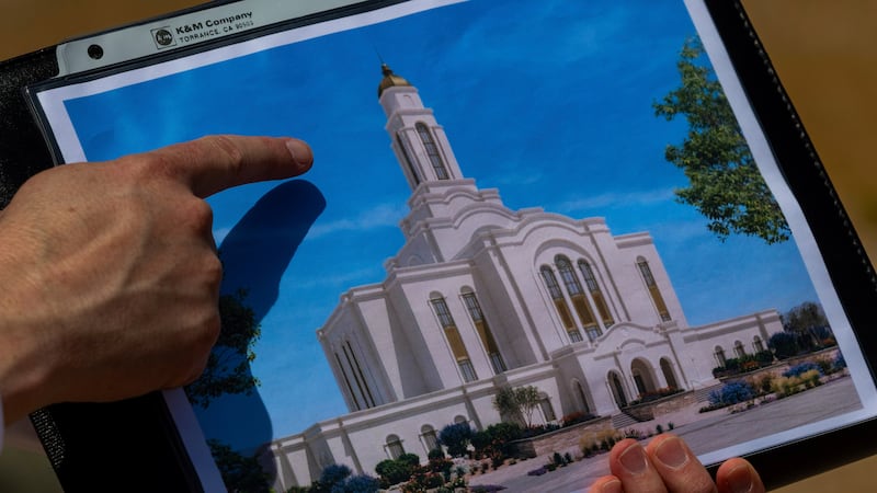 Bud Stoddard, a regional church leader, holds a rendering of the temple planned by The Church...