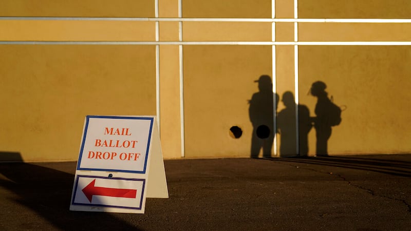 People wait outside of a polling place on Election Day, Tuesday, Nov. 3, 2020, in Las Vegas....