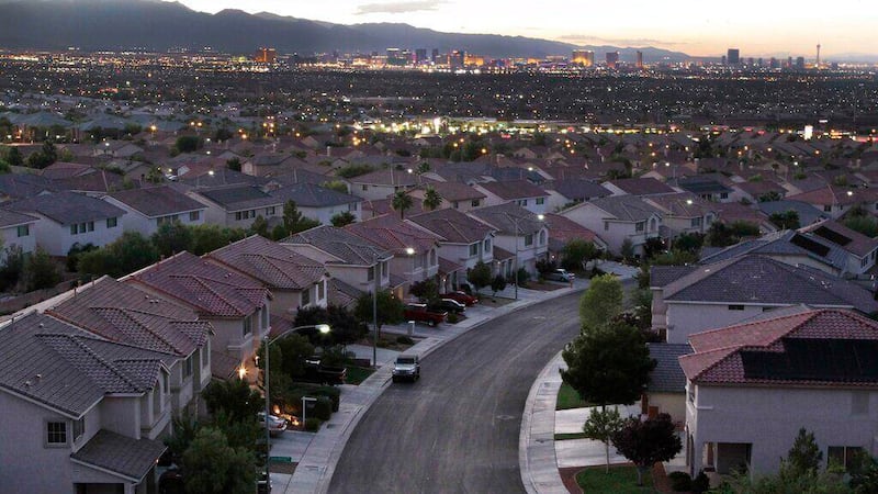 The Las Vegas Strip glows at dusk within view of new homes built on the edge of town, Tuesday,...