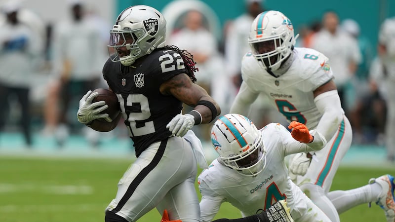 Miami Dolphins cornerback Kader Kohou (4) grabs Las Vegas Raiders running back Alexander...