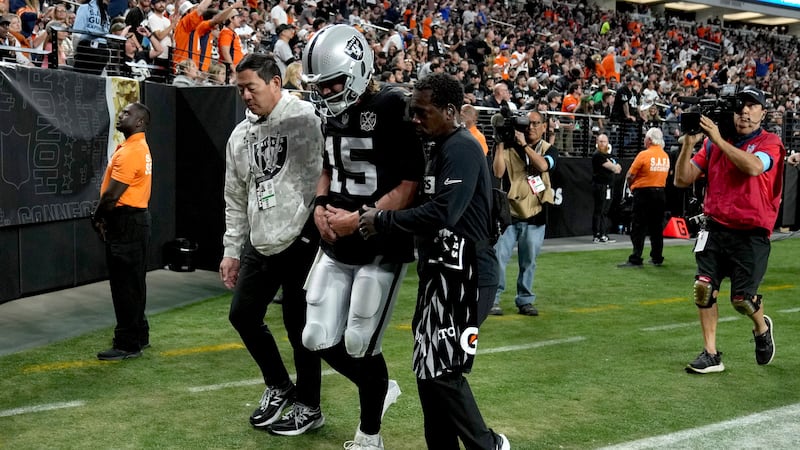 Las Vegas Raiders quarterback Gardner Minshew (15) is helped off the field after an injury...