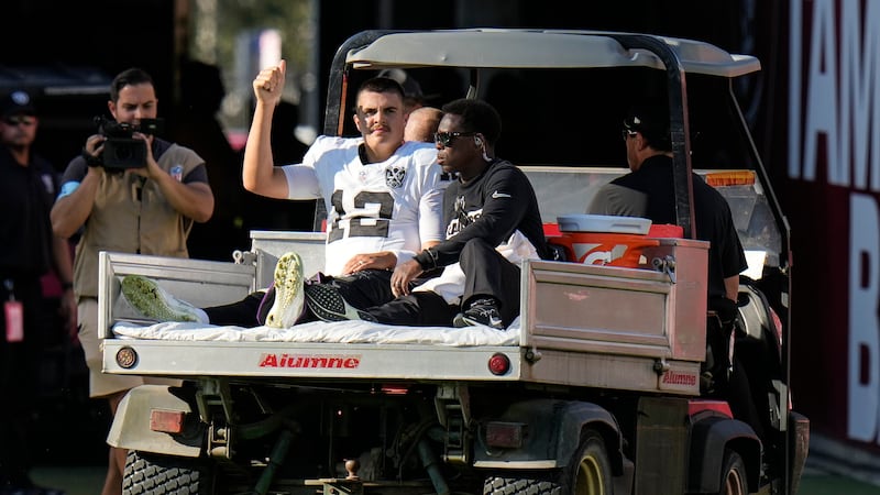 Las Vegas Raiders quarterback Aidan O'Connell (12) is taken off the field after an injury...