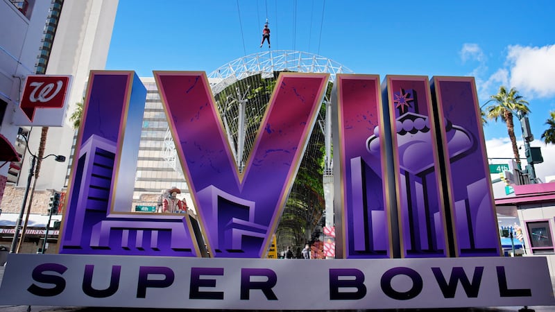 People ride a zip line above a sign for the Super Bowl ahead of the Super Bowl 58 NFL football...