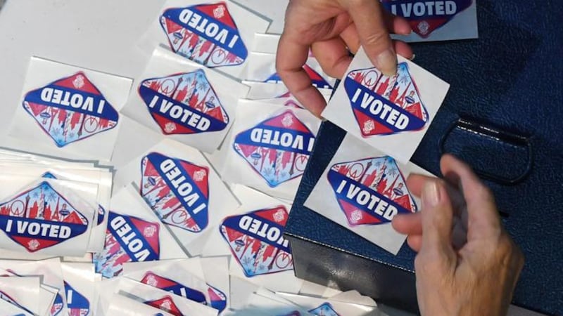 A voter receives a Las Vegas Strip-themed "I Voted" sticker after voting at the Galleria at...